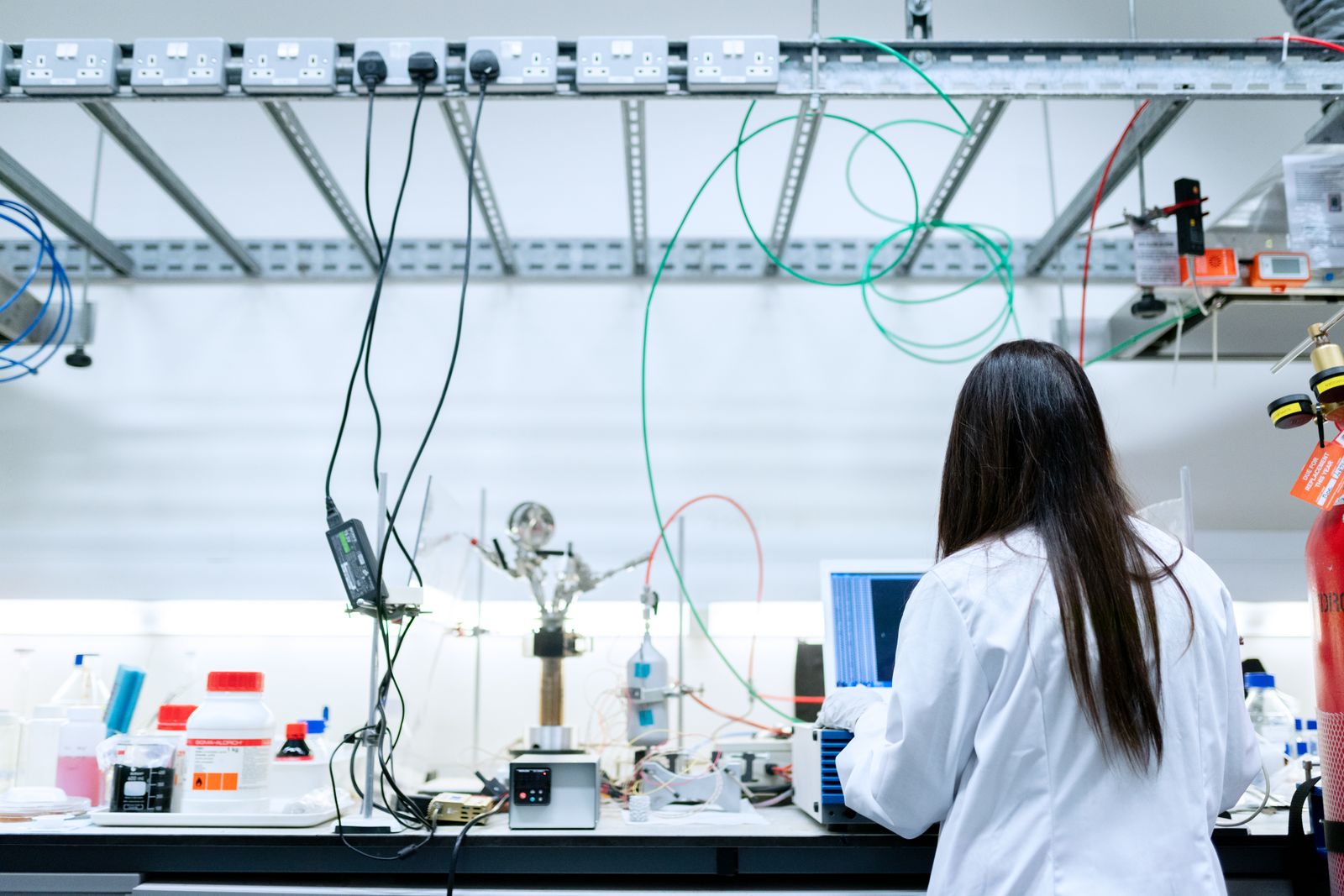 Scientist in a lab coat working with glassware at a modern laboratory bench