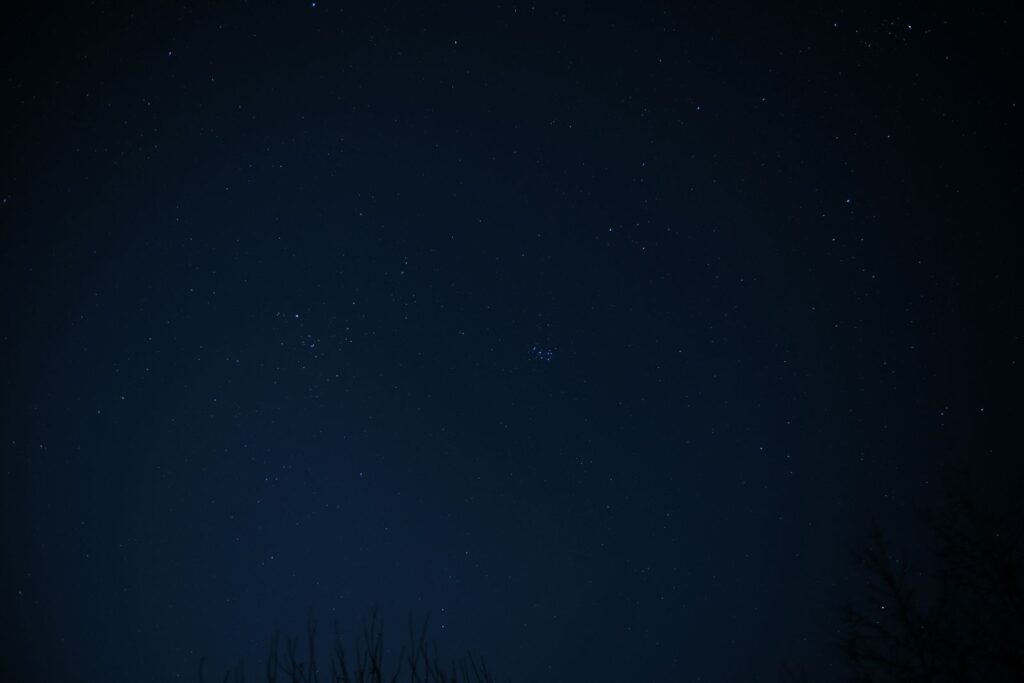 Star-filled night sky above a dark horizon