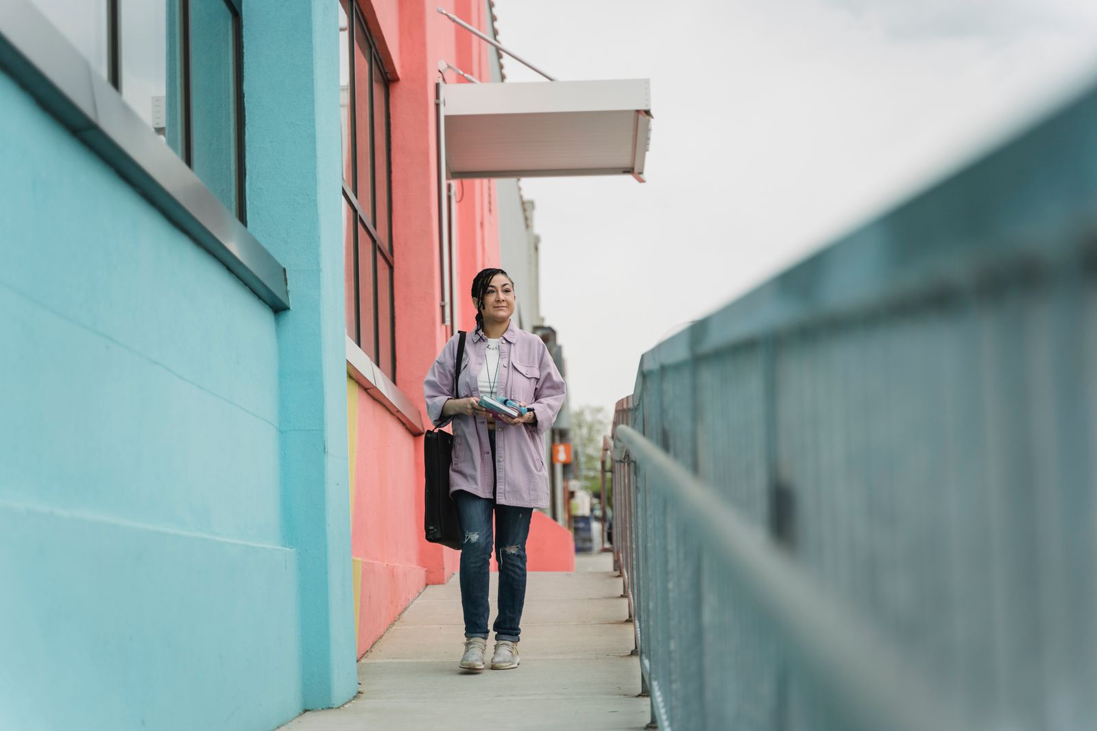 Woman walking past colourful buildings on a city street