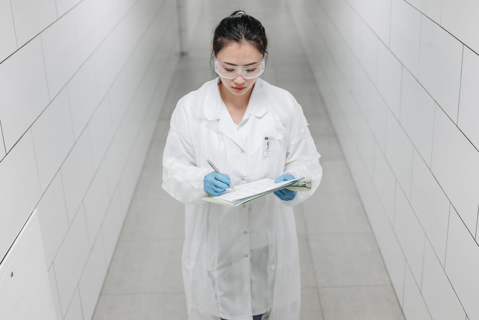 Researcher in a lab coat reviewing testing documentation at a bench