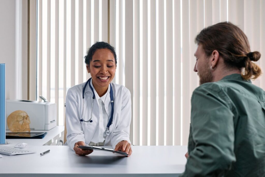 Clinician and patient talking together during a consultation in a bright room