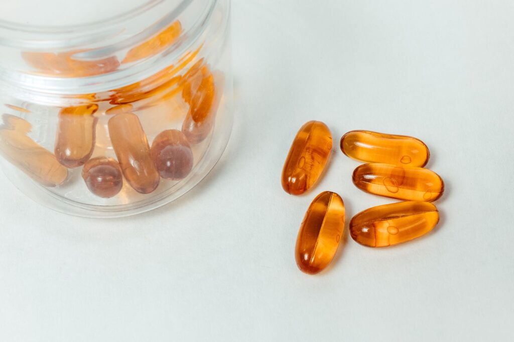 Amber capsules spilling from a glass container