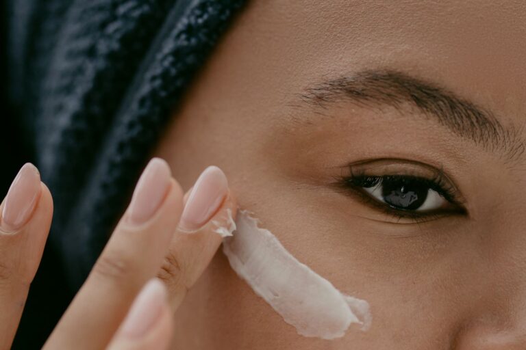Close view of a woman applying cream to her cheek