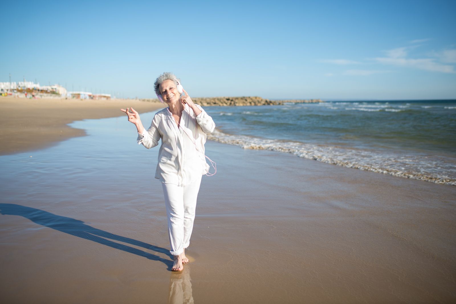 An older woman listening to music outdoors on a sunny day