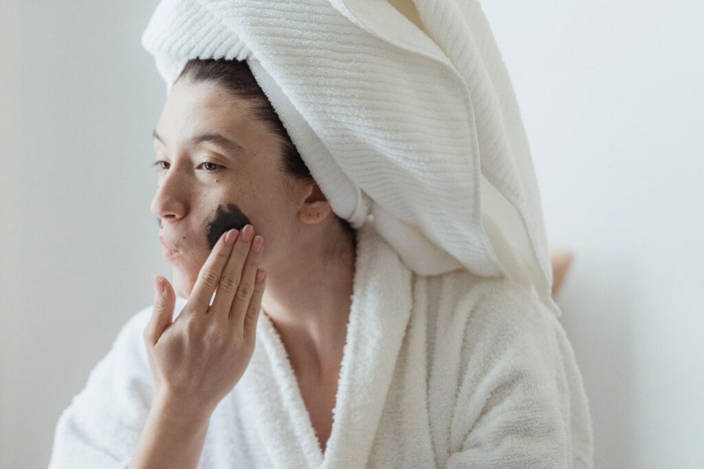 A woman applying a face mask as part of a morning routine
