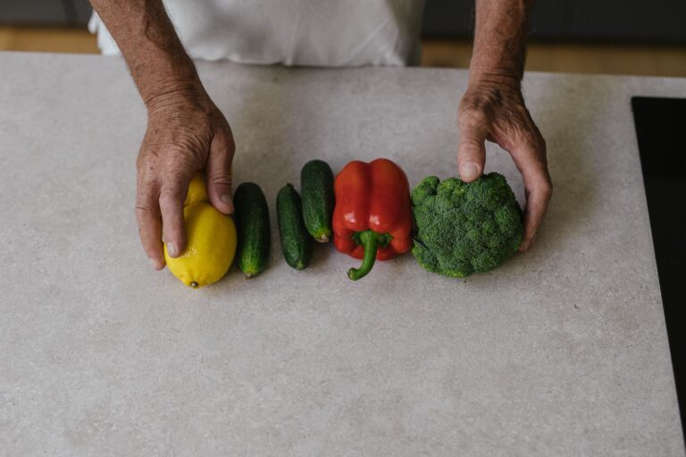 Hands arranging fresh vegetables on a kitchen counter
