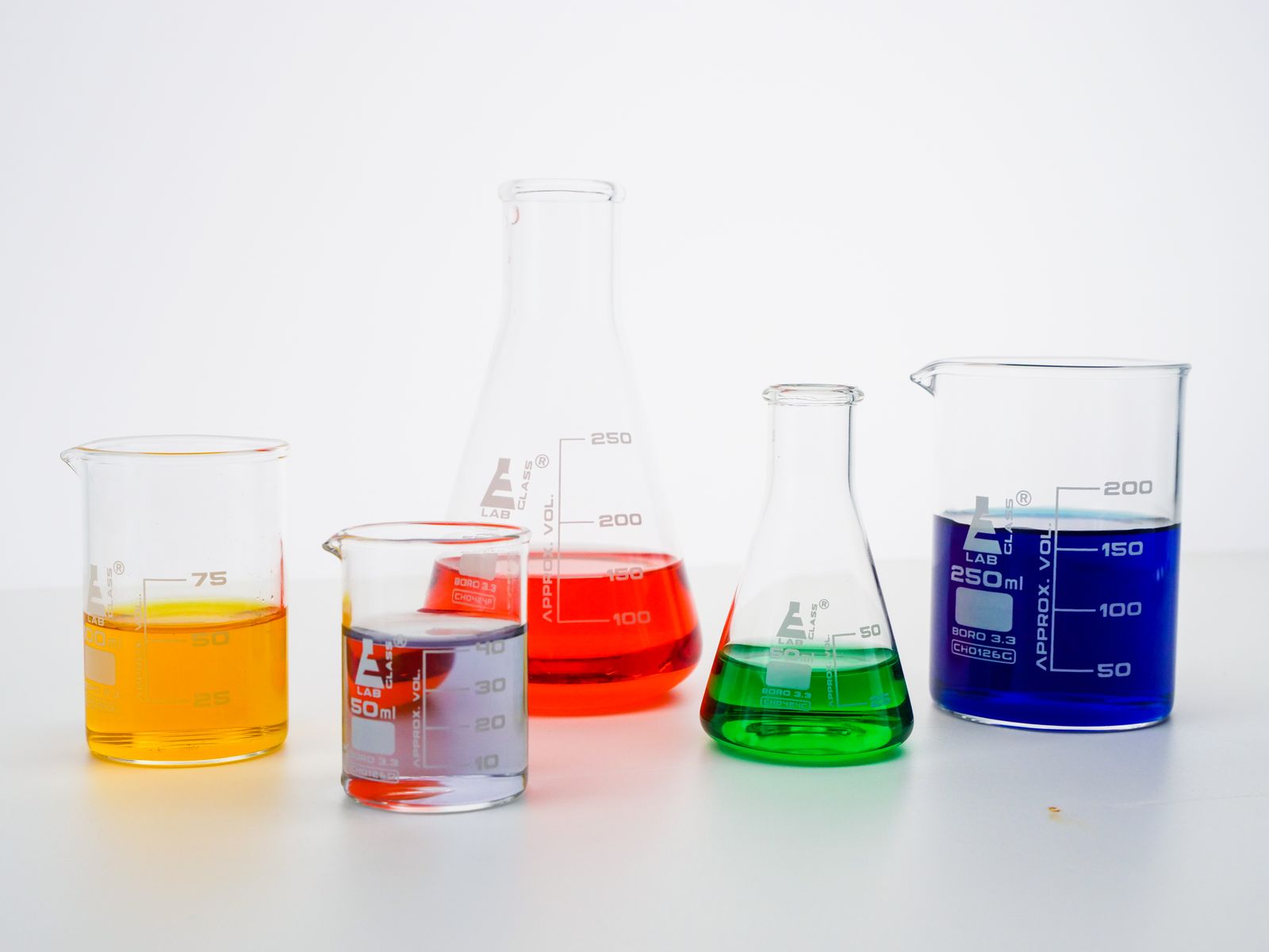 Laboratory beakers holding coloured liquids during analysis