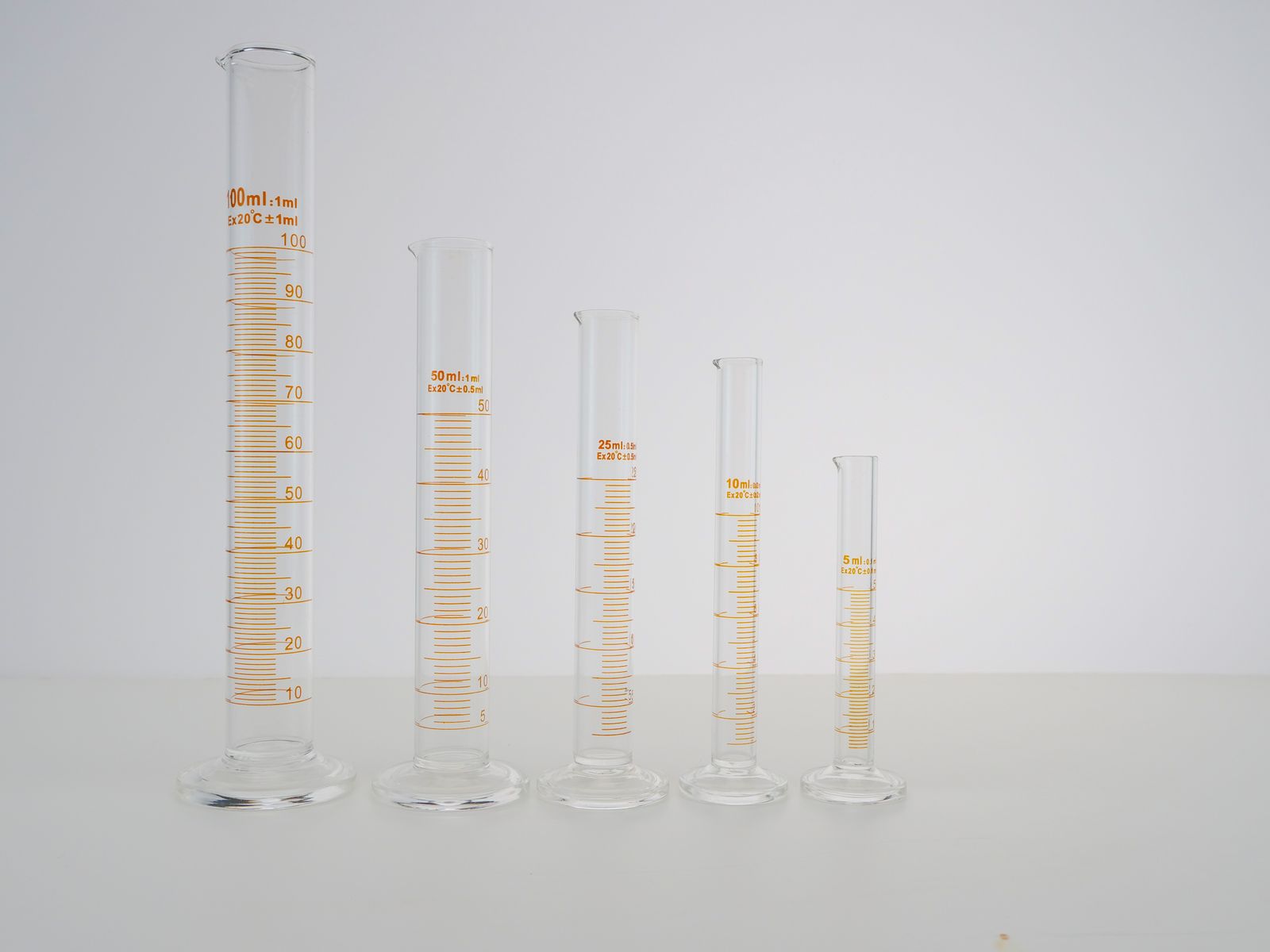 A row of graduated cylinders in different sizes on a laboratory surface