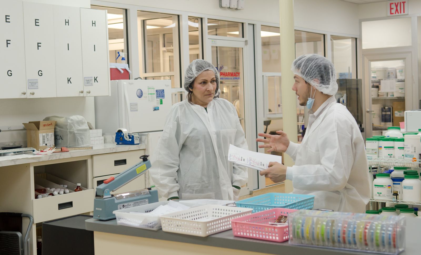 Laboratory workers in white coats reviewing testing paperwork
