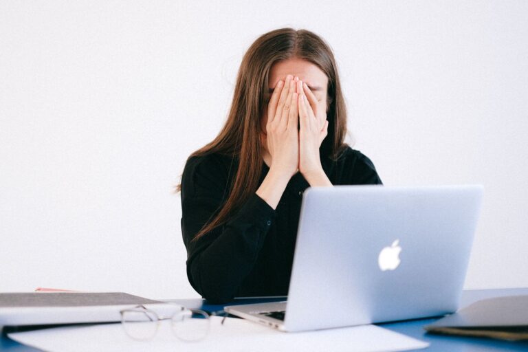 A woman looking overwhelmed at her desk while working remotely