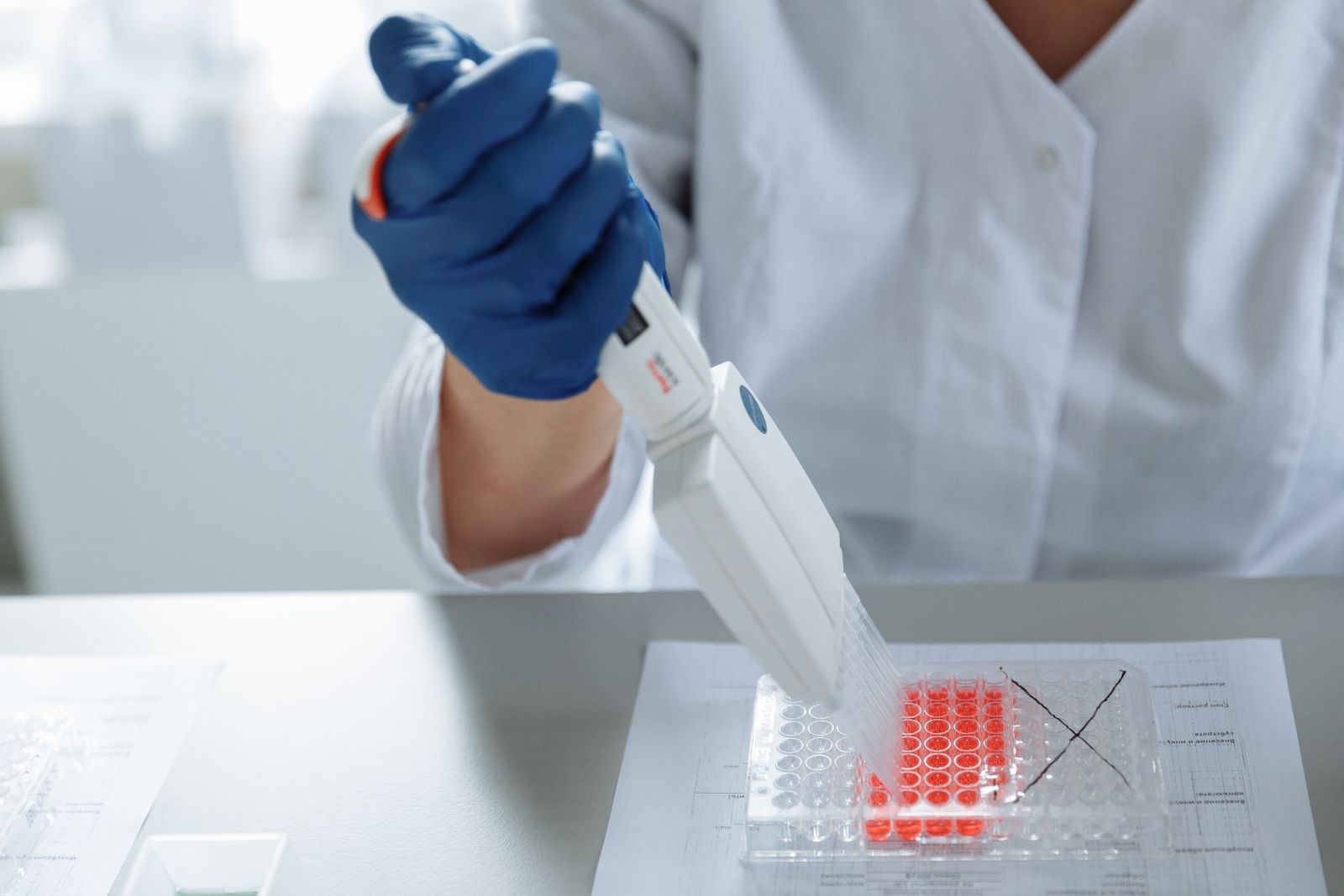 A scientist using a pipette in a sterile laboratory setting