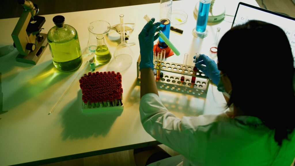 A researcher examining vials in a laboratory setting
