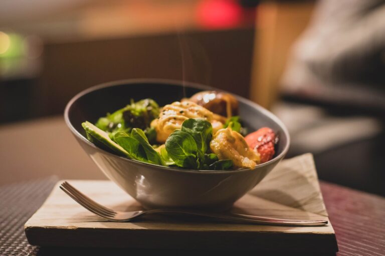 A bowl of fresh salad with greens and grilled chicken