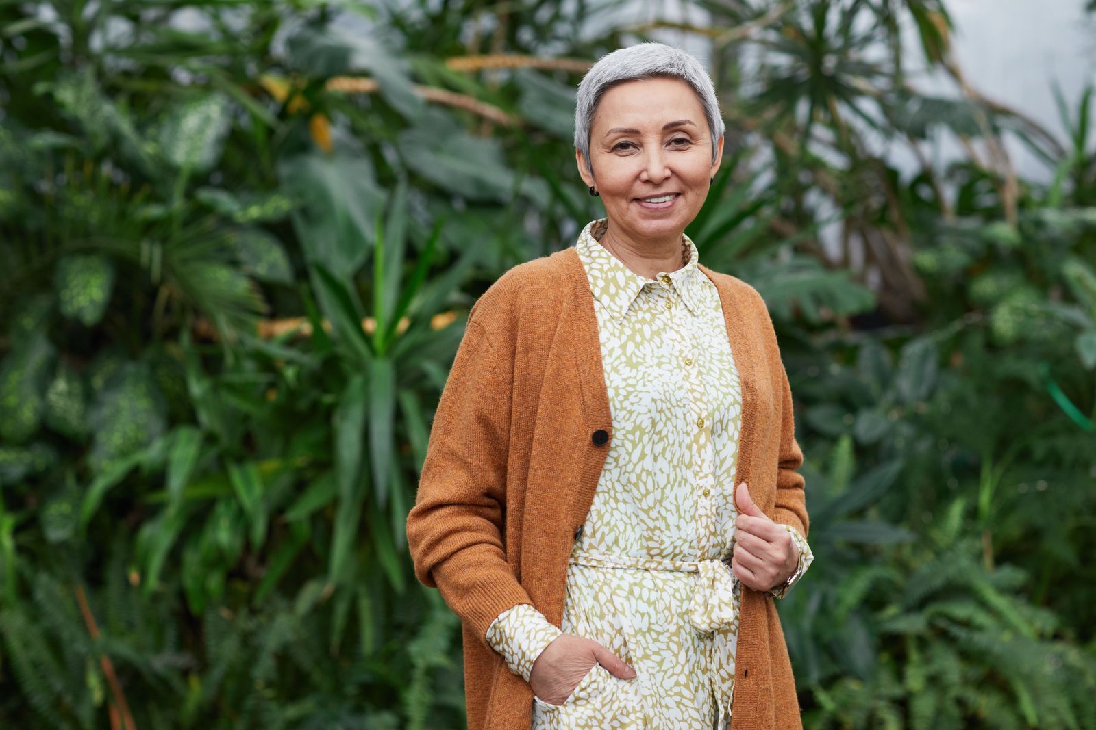 A smiling older woman in a cardigan indoors