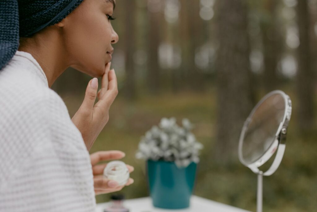 A woman following a skincare routine in a calm outdoor setting