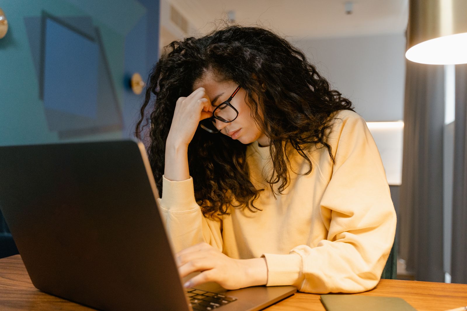 A woman with glasses looking tired while working