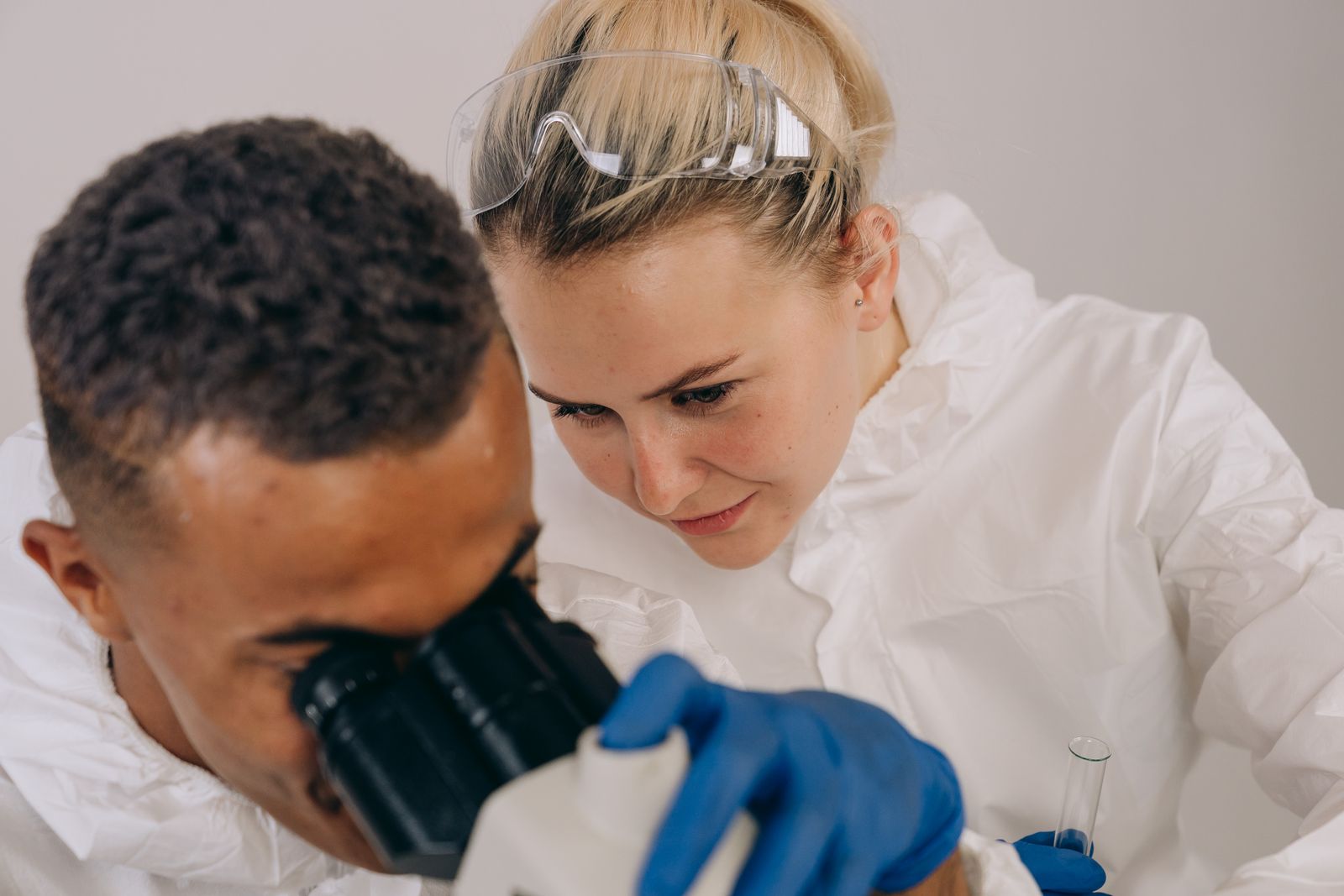 Two researchers working together at a microscope in a laboratory