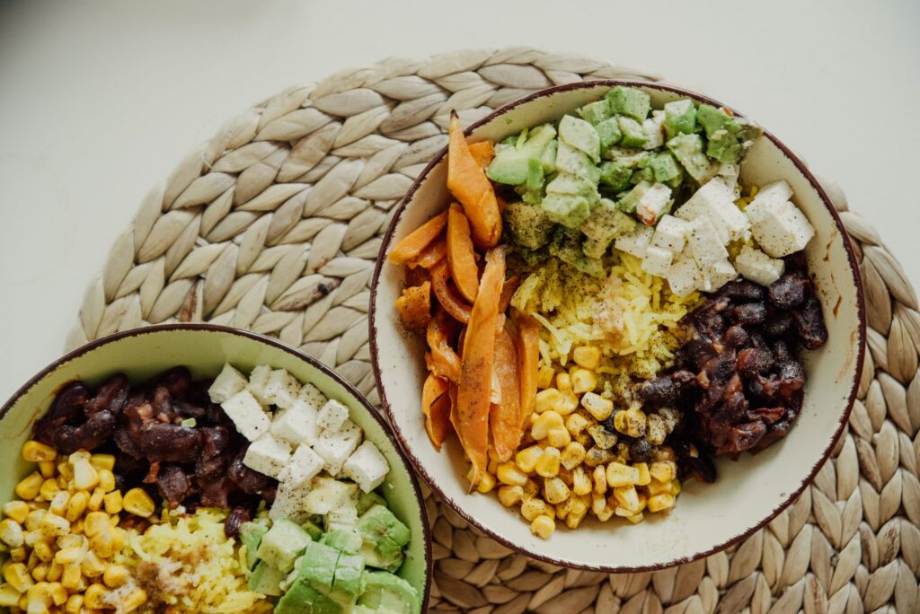 Overhead view of vegetarian bowls with avocado, corn and beans