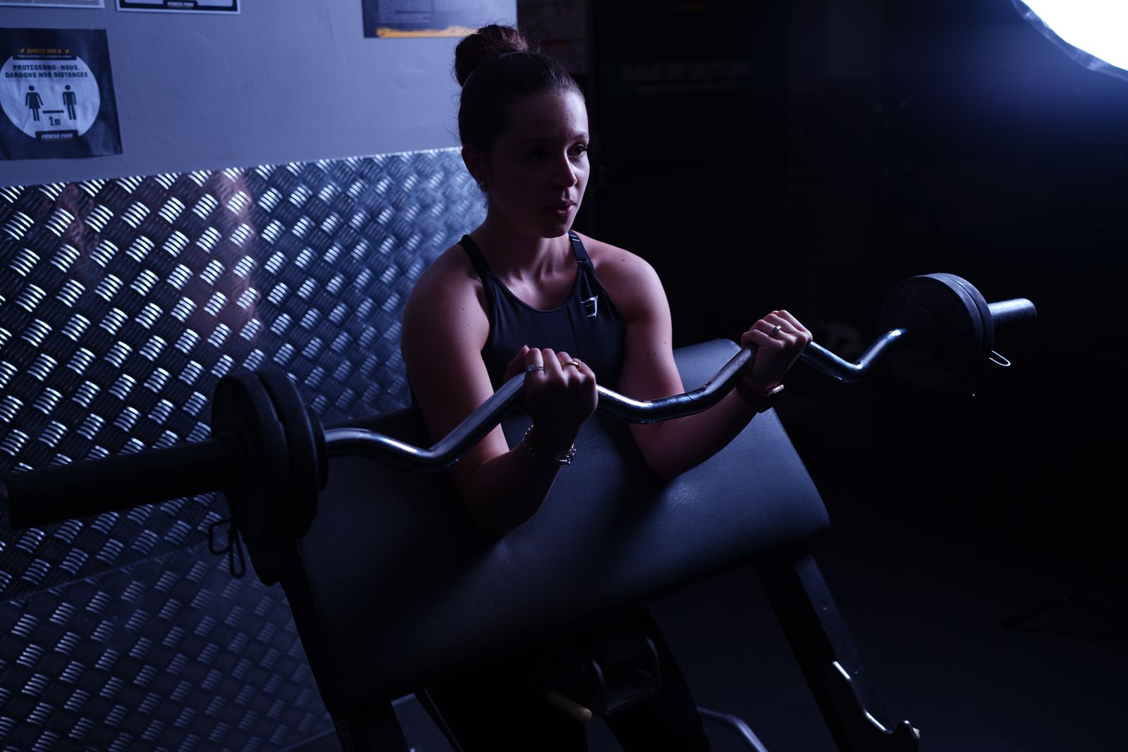 A woman lifting a barbell during a gym session