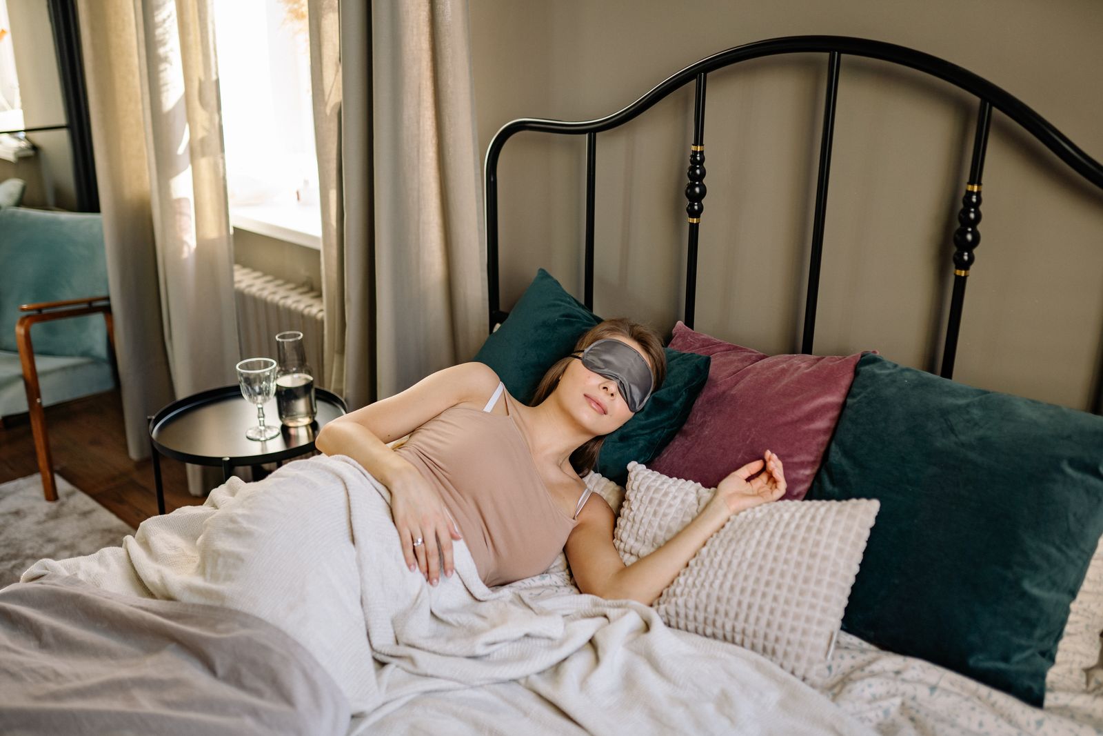 A woman sleeping with an eye mask among soft pillows