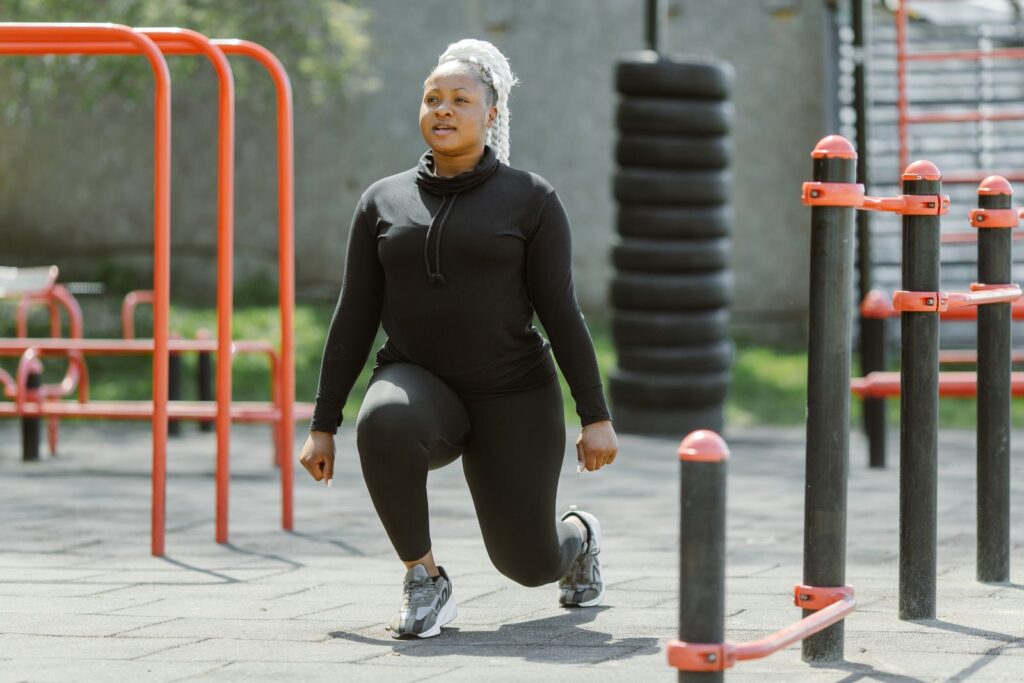 A woman performing lunges at an outdoor training area