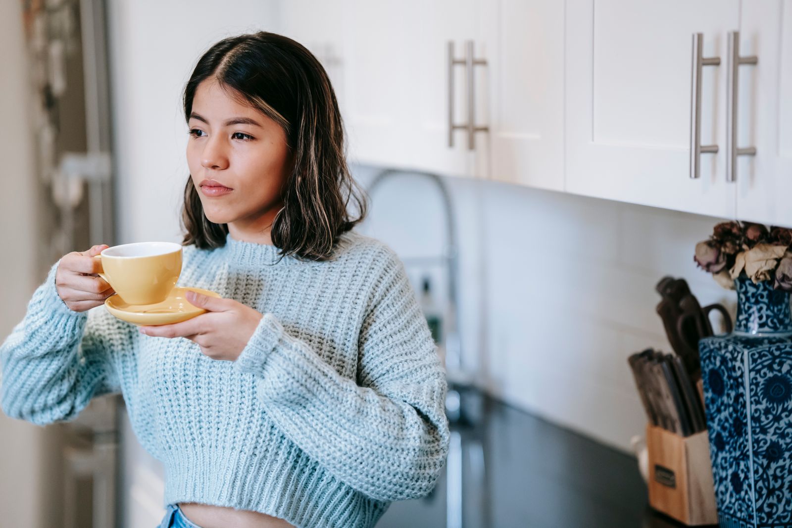 A woman holding a mug in a relaxed indoor setting