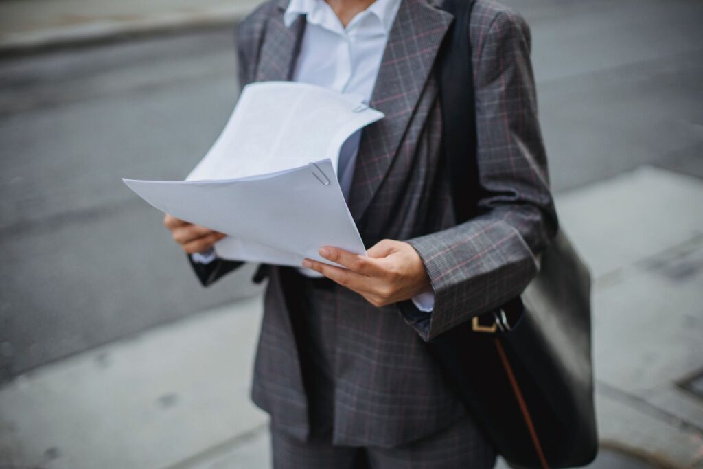A woman reviewing printed documents outdoors