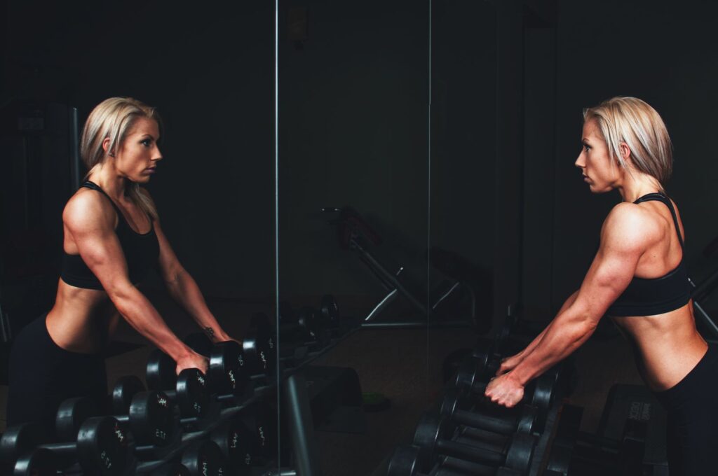 A woman doing strength training with dumbbells in a gym