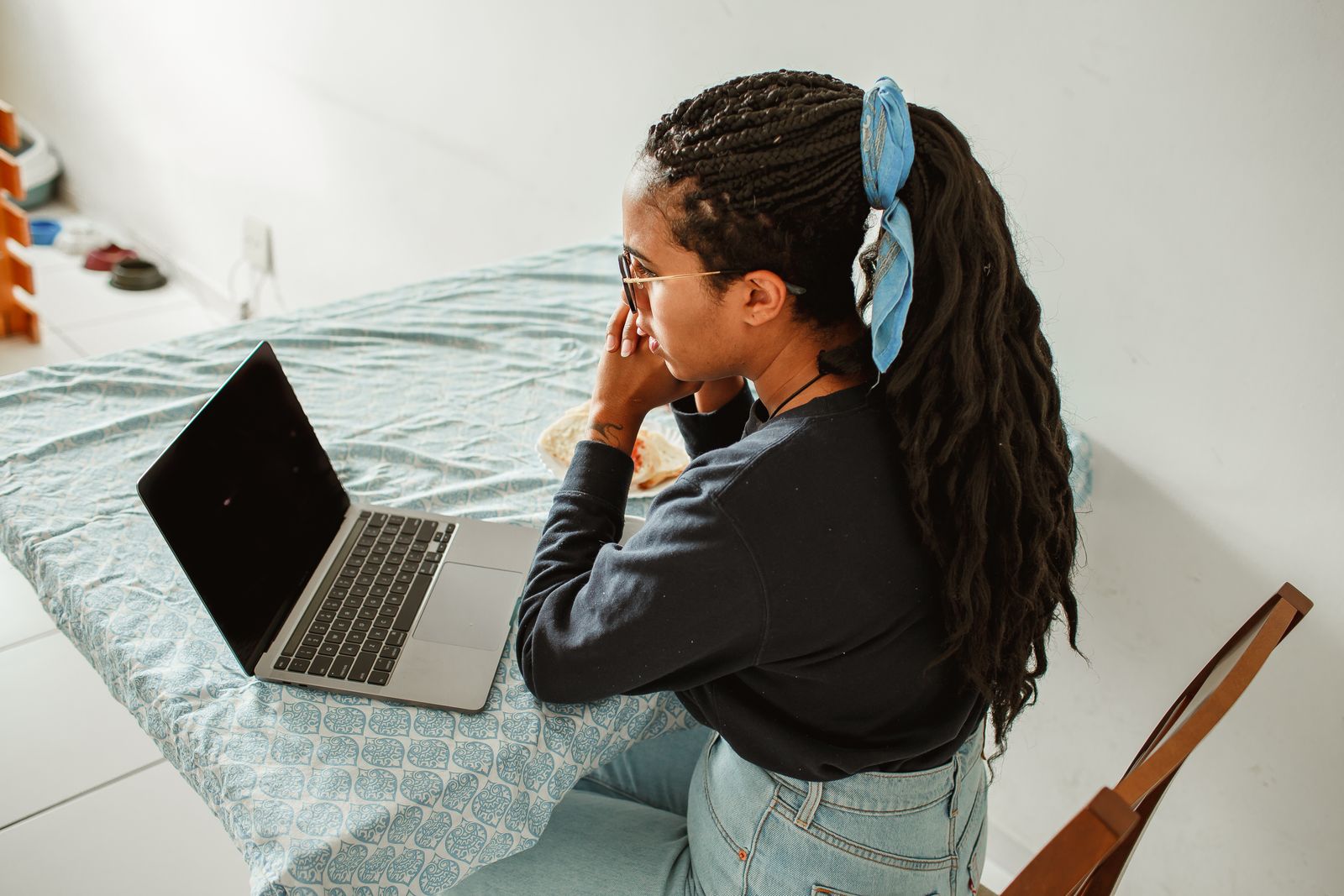 A woman studying on a laptop at a table at home