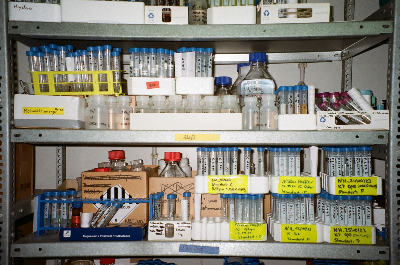 Laboratory shelves lined with test tubes and sample vials