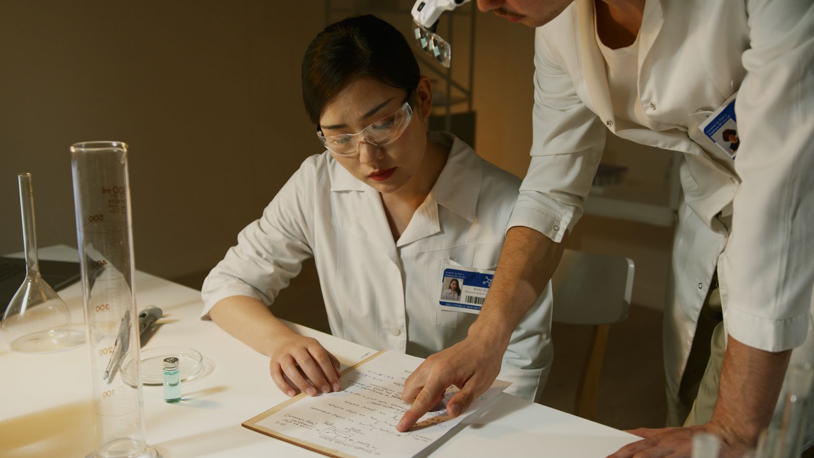 Researchers in lab coats reviewing experimental notes during analysis
