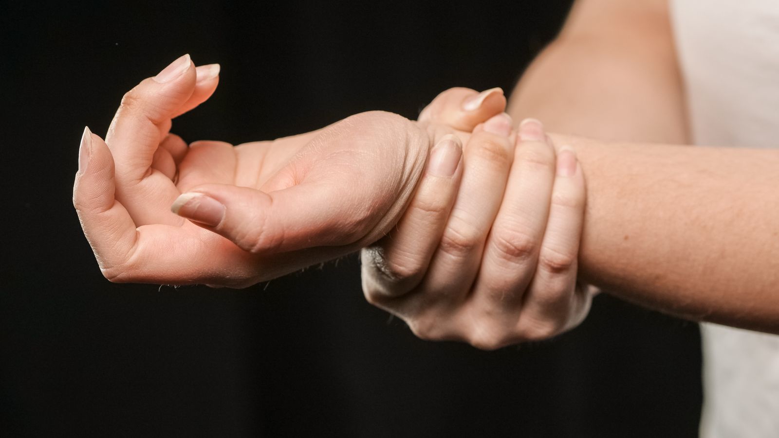 A person resting a hand on their knee while seated