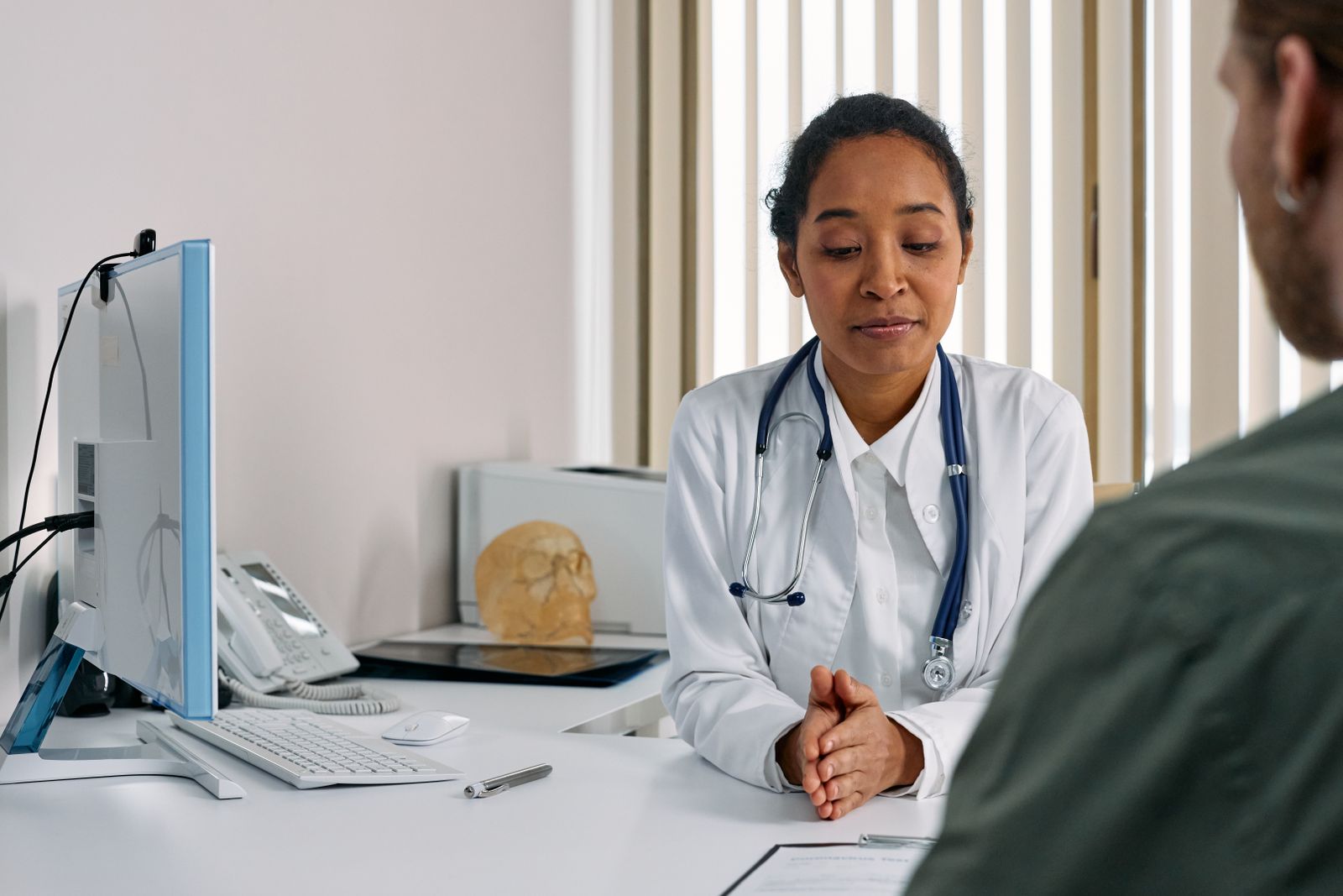 A healthcare worker writing on a clipboard in a clinic