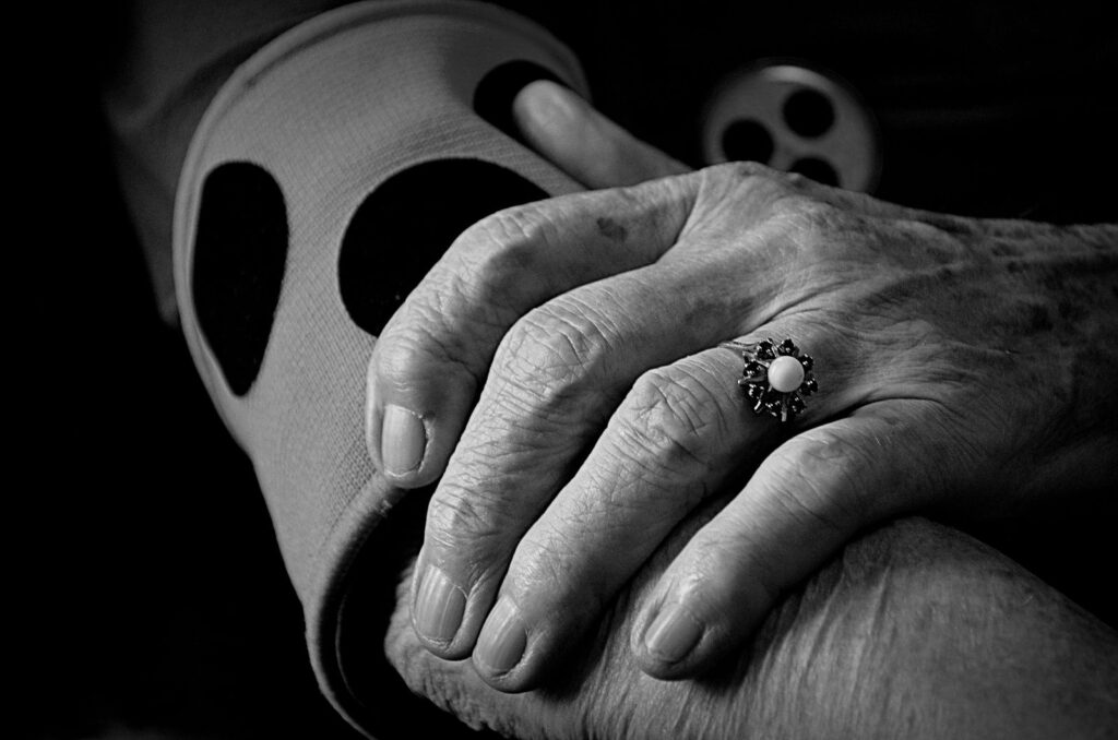 Close-up of an older person clasping their hands
